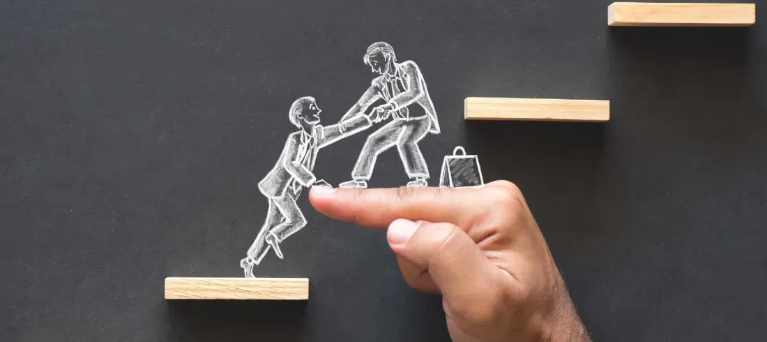 Main aidant un personnage dessiné à la craie à gravir des marches en bois, illustration de l'accompagnement SEO à Tours