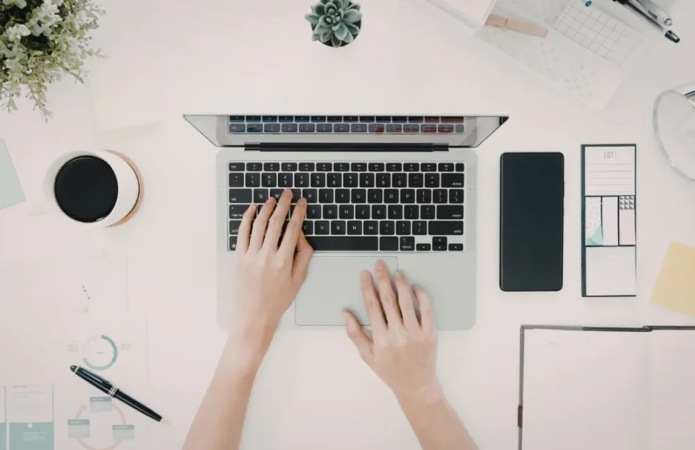 deux mains qui tappent sur un clavier pour symboliser un pilier du seo appelé contenu éditorial clair