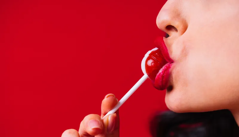 femme qui suce une sucette symbolisant la luxure
