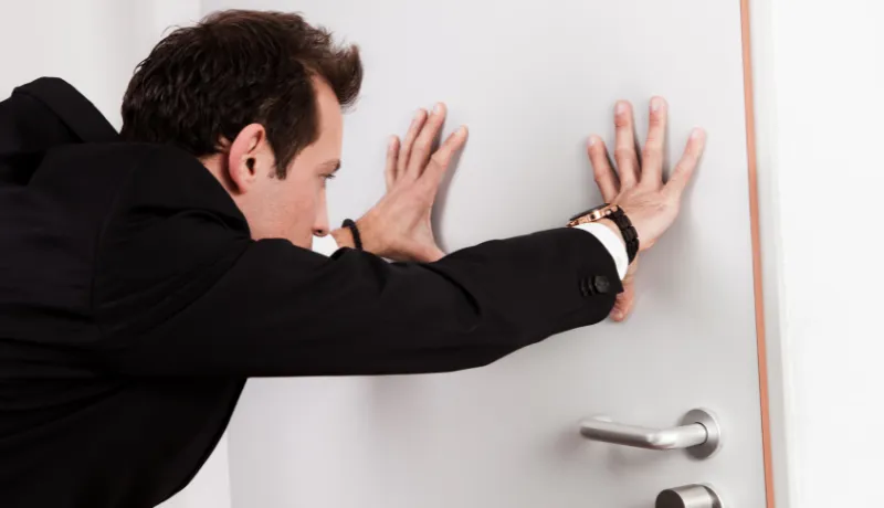 homme tenant une porte fermée pour illustrer un site qui ne convainc pas