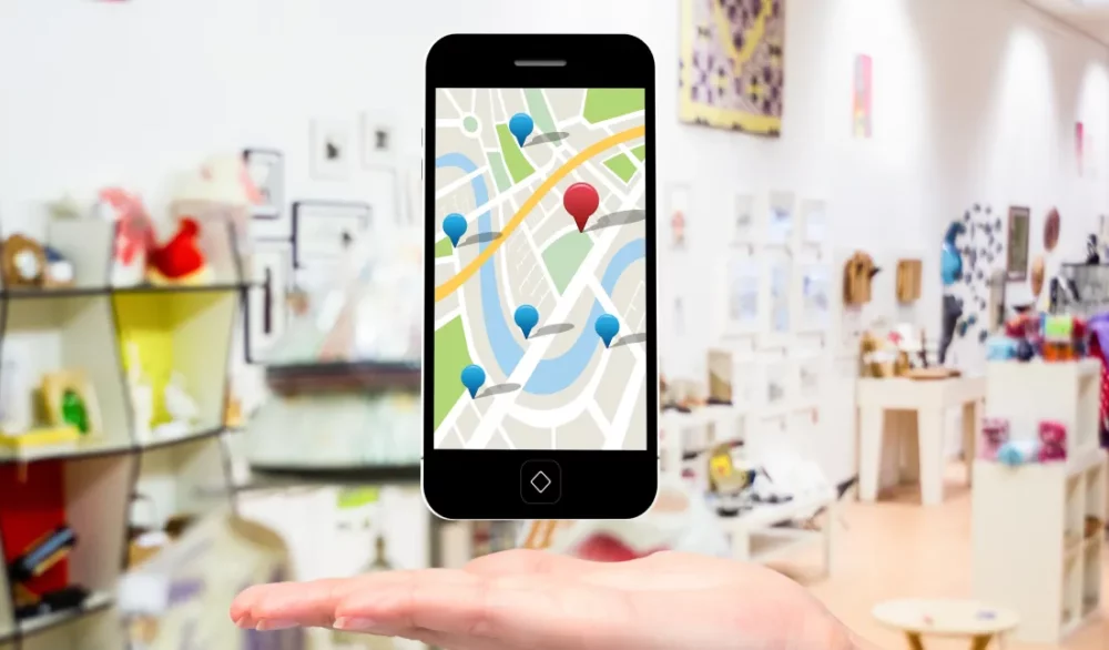portable en lévitation au dessus d'une main et qui affiche une carte de localisation Google maps pour illustrer la visibilité analyser lors de l'audit seo