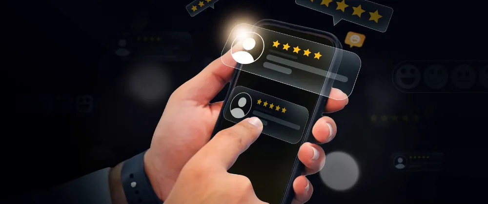 main qui tient un téléphone portable pour laisser un avis client avec des étoiles jaunes