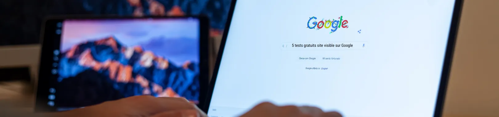 main d'homme qui va taper une requête sur Google : 5 tests gratuits site visible Google