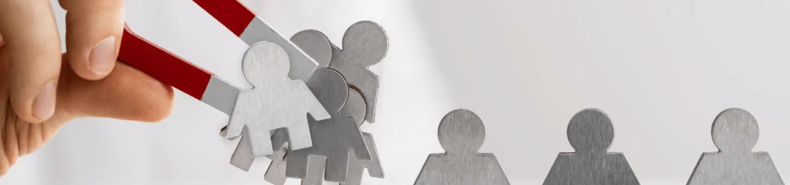 aimant qui attirer des personnages en métal pour illustrer l'article attirer des clients sur sont site web sans publicité