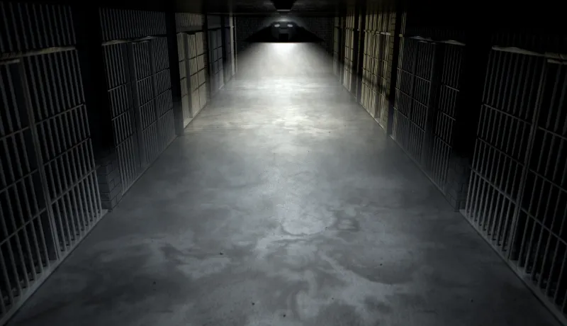 vue d'un couloir de prison avec les barreaux des cellules pour illustrer la nouvelle intitulée le châtiment