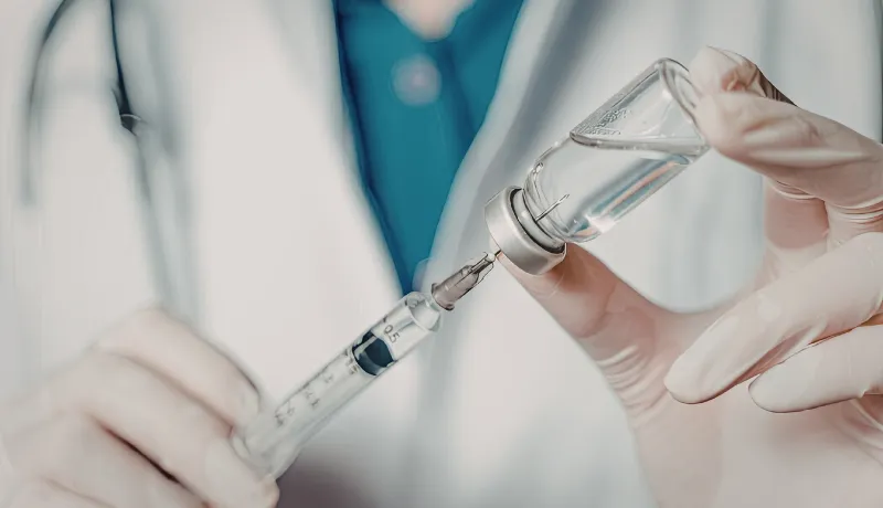 médecin qui rempli une seringue